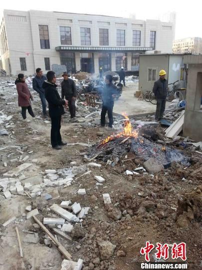常州九龙仓地产的擎天半岛建筑工地，建筑工人正在焚烧的建筑垃圾堆边烤火 唐娟 摄