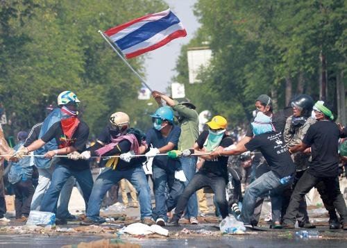 2日,在泰国首都曼谷的政府大厦附近,抗议者用绳子拉开警方设置的路障。
