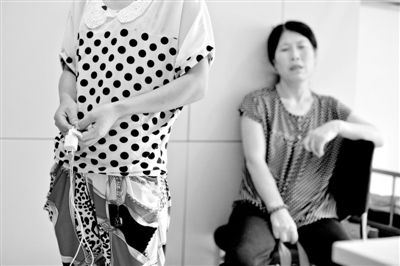 昨日,武建同的妹妹手拿事发时的充电器站在海淀医院ICU病房外,等候哥哥醒来。新京报记者 周岗峰 摄 昨日,武建同的妹妹手拿事发时的充电器站在海淀医院ICU病房外,等候哥哥醒来。新京报记者 周岗峰 摄